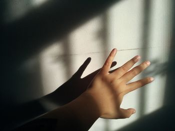 Close-up of hand touching shadow on wall