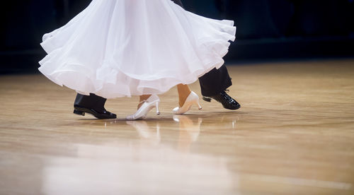 Low section of couple dancing on floor