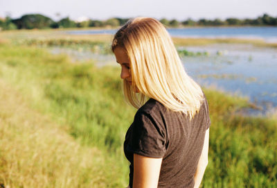 Side view of young woman standing on field