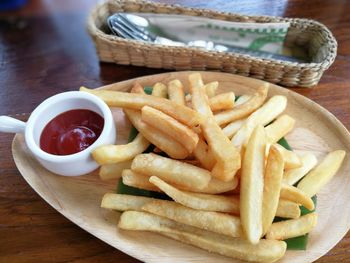 Close-up of fries and vegetables in plate on table