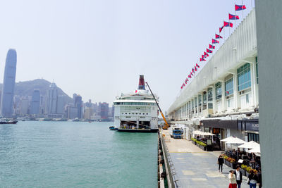 View of city buildings by sea against sky