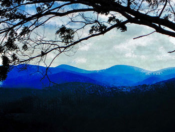 Scenic view of mountains against blue sky