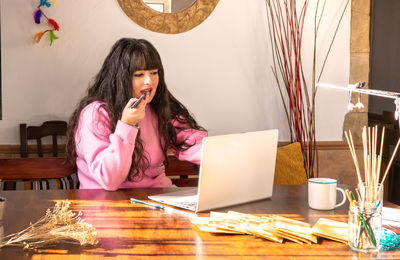Portrait of young woman sitting at home
