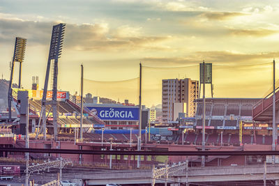 Commercial dock against buildings in city at sunset