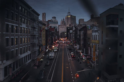 High angle view of traffic on city street amidst buildings at night