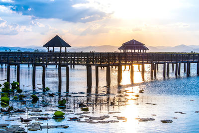 Pier over sea against sky during sunset