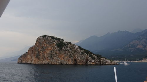 Scenic view of sea and mountains against sky