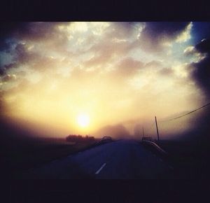 Road against cloudy sky at sunset