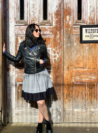 Young woman standing against wall