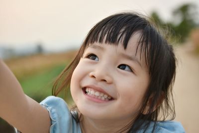 Close-up of cute smiling girl looking up