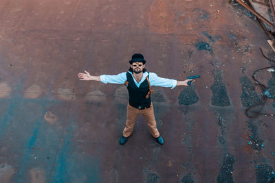 High angle portrait of young man standing against wall