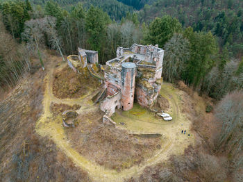 High angle view of old ruin amidst trees on field