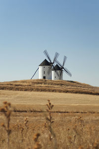 Traditional windmill on field against sky