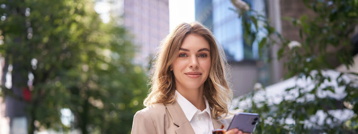 Portrait of young businesswoman standing outdoors