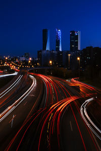 Light trails on road against sky at night