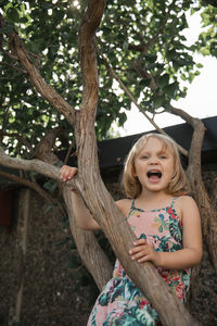 Girl on tree looking at camera