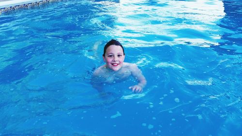 Portrait of smiling young woman swimming in pool