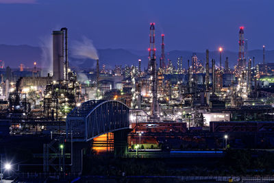 High angle view of illuminated factory against sky at night