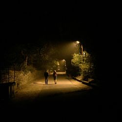 Full length rear view of woman in dark room