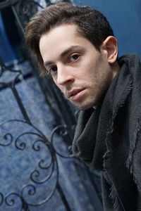 Portrait of young man wearing warm clothing standing against wall
