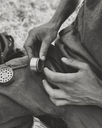 Midsection of man holding metal