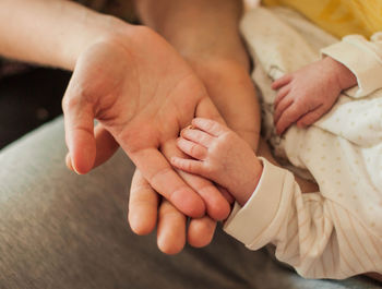 Midsection of mother and baby hands