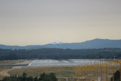 Scenic view of field by mountains against sky