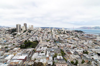 Aerial view of buildings in city against sky