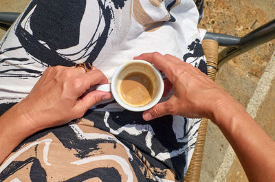 Cup of coffee in woman's hands - shot from above