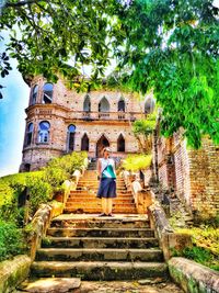 Woman standing by staircase outside building