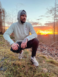 Portrait of young man sitting on field