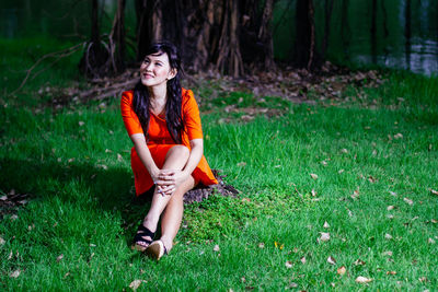 Portrait of young woman sitting on grassy field