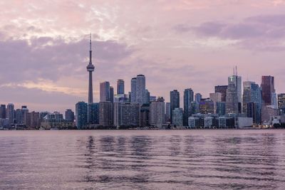 Modern buildings in city against cloudy sky