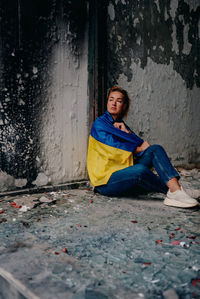 Portrait of young woman sitting on street