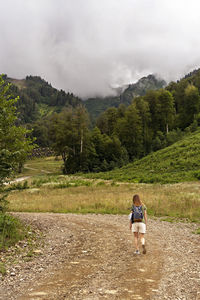 Rear view of man on mountain against sky