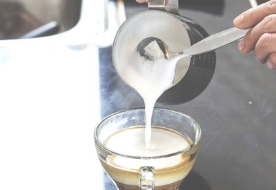 Close-up of hand pouring drink in glass