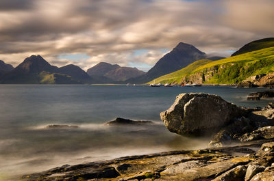 Scenic view of sea and mountains against sky