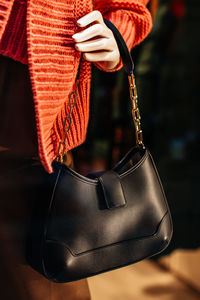 Classic black leather women's handbag with gold chain. fashion details