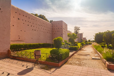 Footpath amidst buildings against sky