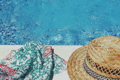 High angle view of scarf and hat by swimming pool during sunny day