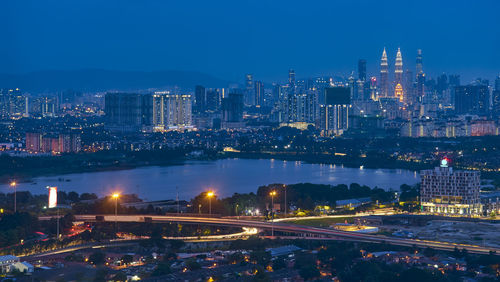 Illuminated buildings in city against sky at night