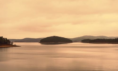 Scenic view of lake against sky at sunset