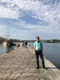 Full length of man standing on pier by sea against sky