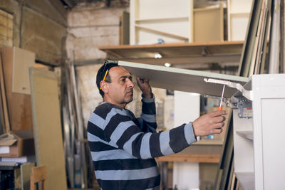 Carpenter making furniture in workshop