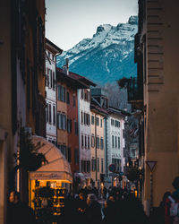 Group of people on street amidst buildings in city