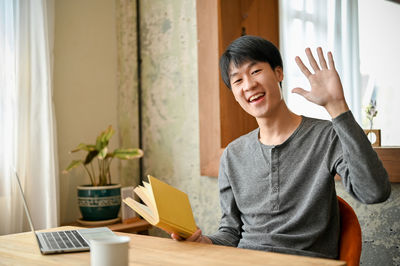 Portrait of young woman using laptop at home