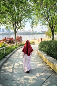 Rear view of woman walking on footpath