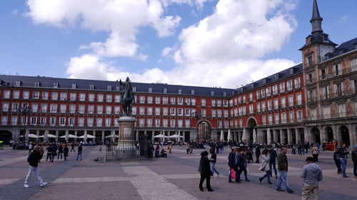 People walking at plaza mayor against sky in city