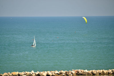 Sail boat and kitesurf over the sea