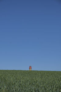 Scenic view of field against clear blue sky